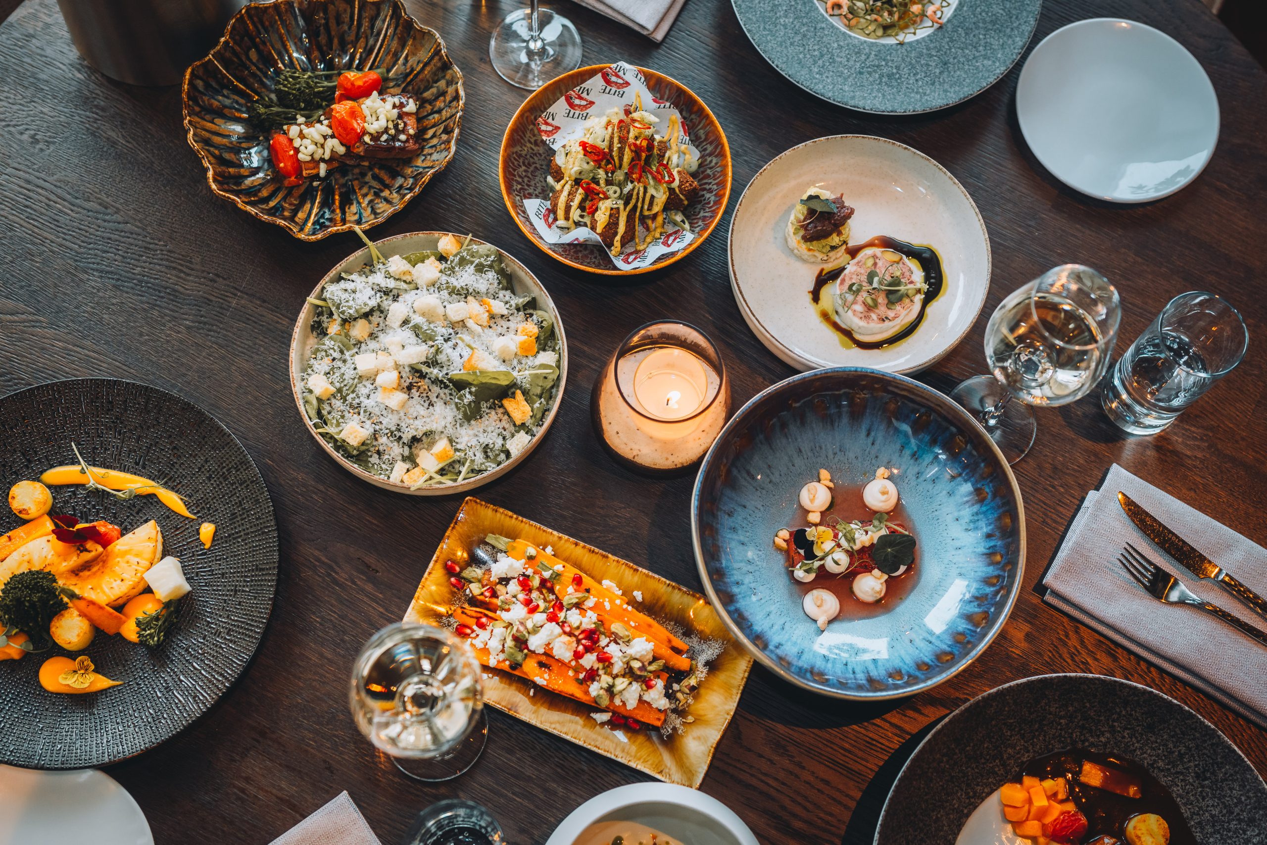 Verschillende kleine gerechten en wijn op tafel bij NOVO